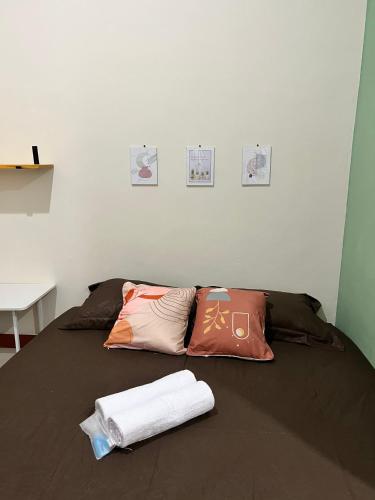 a bed with pillows and towels on top of it at Tuwin Guest House Syariah in Yogyakarta