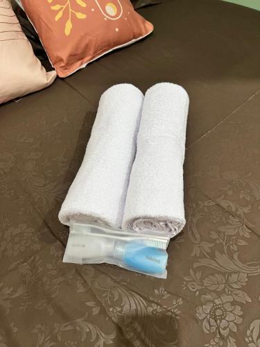 a stack of towels and a toothbrush on the floor at Tuwin Guest House Syariah in Yogyakarta