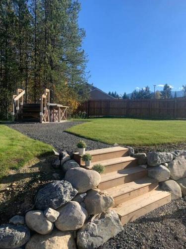 a wooden staircase in a yard with rocks and a playground at The White House in Golden