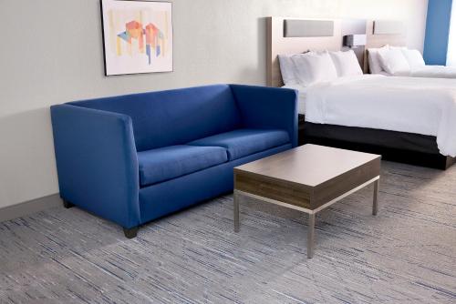 a blue couch and a coffee table in a hotel room at Holiday Inn Express & Suites Chicago North Shore - Niles by IHG in Niles
