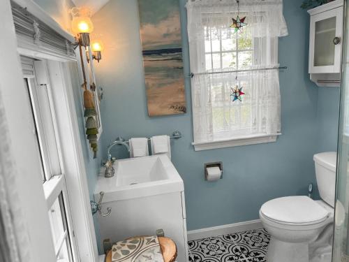 a bathroom with a toilet and a sink and a window at Seaside Cottages - Cottage 37 - Sundancer in South Yarmouth