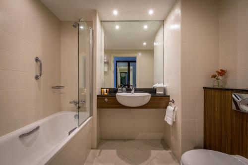 a bathroom with a tub and a sink and a toilet at The Killeshin Hotel Portlaoise in Portlaoise