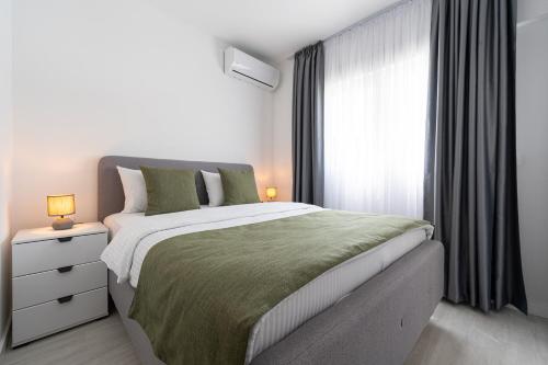 a bedroom with a large bed and a window at Millennium Apartments Budva in Budva