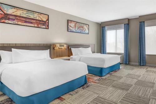 a hotel room with two beds and windows at Hilton Garden Inn Albany-SUNY Area in Albany