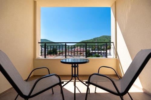 a balcony with a table and two chairs and a window at Millennium Apartments Budva in Budva