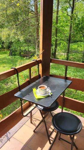 a table and two chairs on a porch with a cup of coffee at Hunters Lounge Apartments 