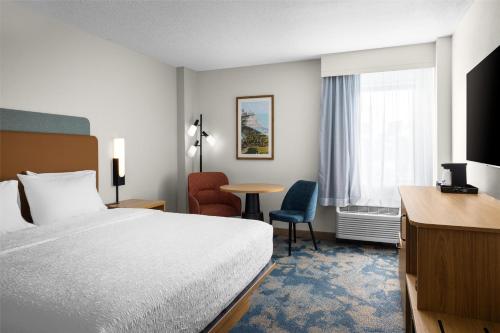 マイアミにあるHampton Inn Miami-Airport Westのベッドと机があるホテルの部屋