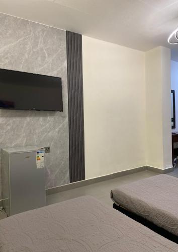 a bedroom with a flat screen tv on a wall at Eden Hotel in Aqaba
