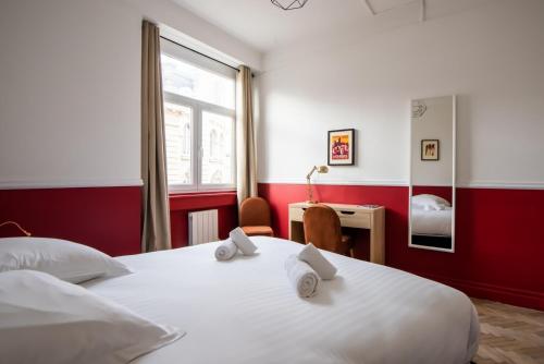 une chambre avec un grand lit blanc et un bureau dans l'établissement Amazing Renovated Apartment in the city-center, à Lille