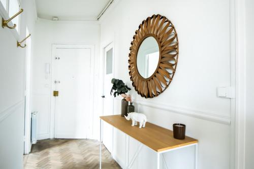 un miroir sur un mur dans un couloir avec une table dans l'établissement Amazing Renovated Apartment in the city-center, à Lille
