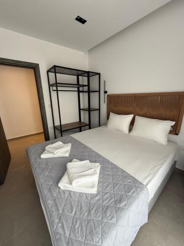 a bedroom with a large bed with two towels on it at G&S Dionisiou Apartment in Paralia Dionysiou