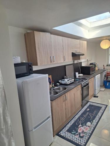 a kitchen with a white refrigerator and a sink at Tc home in Liège