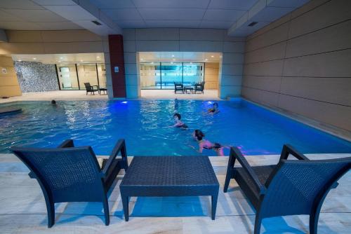 a swimming pool with people in the water at Hotel Mellain in Tuzla