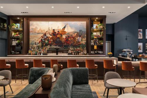 a bar with a painting of a battle on the wall at Hilton Philadelphia City Avenue in Philadelphia