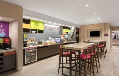 a restaurant with a table and chairs and a counter at Home2 Suites by Hilton Greenville Airport in Greenville