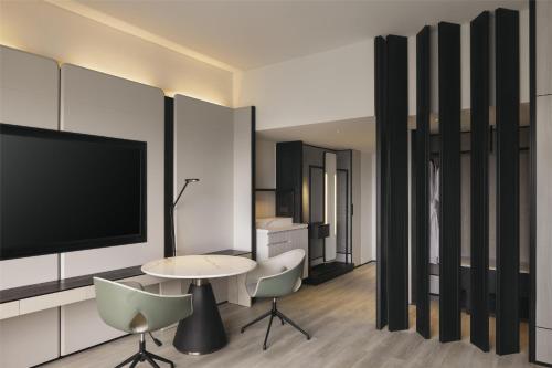 a living room with a tv and a table and chairs at Hilton Singapore Orchard in Singapore