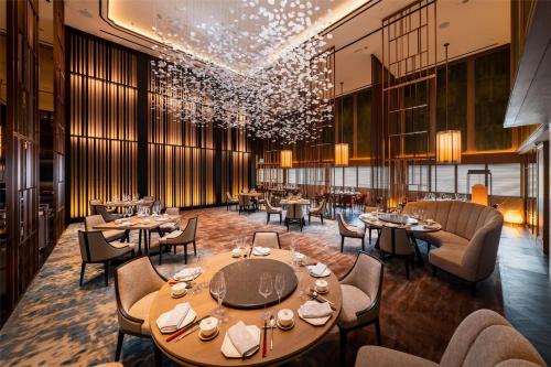 a restaurant with tables and chairs and a chandelier at Hilton Singapore Orchard in Singapore