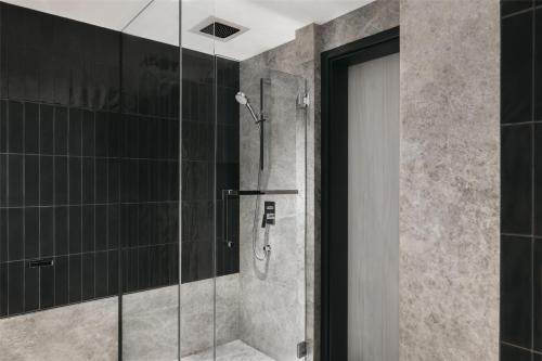 a shower in a bathroom with a glass door at Hilton Singapore Orchard in Singapore