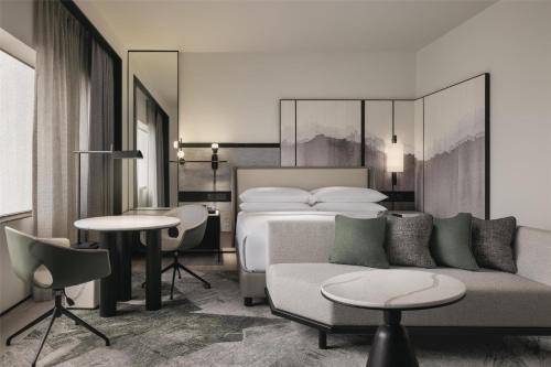 a hotel room with a bed and a couch and tables at Hilton Singapore Orchard in Singapore