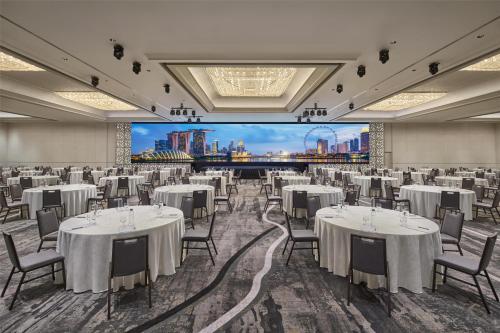 a banquet hall with tables and chairs and a large screen at Hilton Singapore Orchard in Singapore