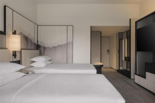 a bedroom with two beds and a flat screen tv at Hilton Singapore Orchard in Singapore