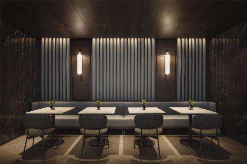 a dining room with a table with chairs and lights at Hilton Singapore Orchard in Singapore
