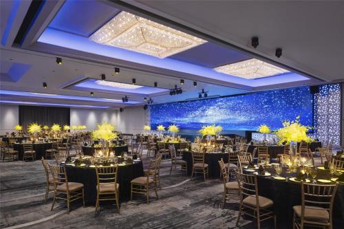 a banquet hall with tables and chairs in front of a wall of stars at Hilton Singapore Orchard in Singapore