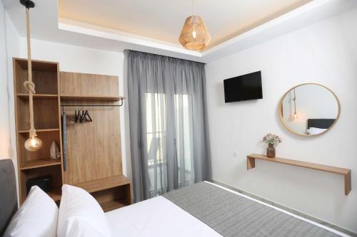 a hotel room with a bed and a mirror at Gregory Luxury Apartments in Pefkohori