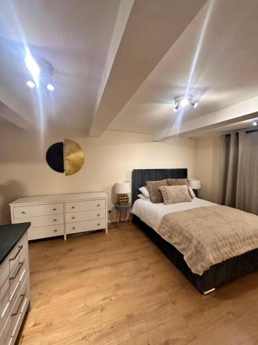 a bedroom with a bed and a dresser and lights at Hope House King Studio in Maidstone