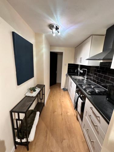 a kitchen with a black counter top and a stove at Hope House King Studio in Maidstone