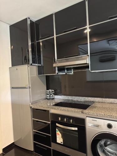 a kitchen with a stove top oven next to a refrigerator at Nadia apartamento in Riffiene