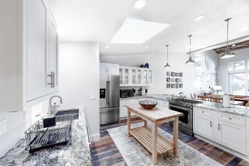 a kitchen with white cabinets and a wooden table at Whale Watchers -Upper in Depoe Bay