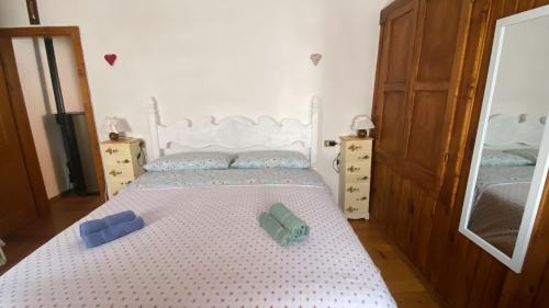 a bedroom with a white bed with two containers on it at La Casa di Theo in Padola