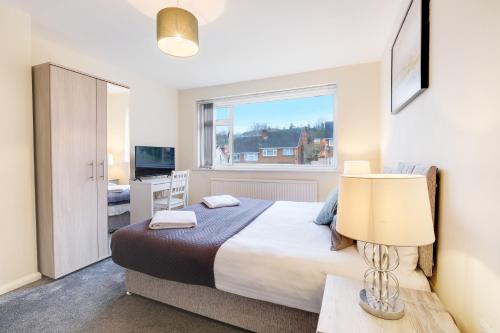 a bedroom with a large bed and a window at 4 Bedroom High Wycombe Home With Free Parking Free WiFi Private Garden - Great Transport Links! in Buckinghamshire