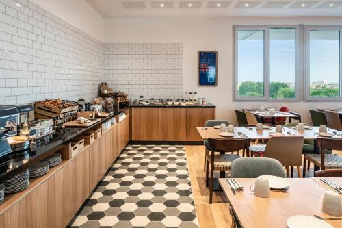 Un restaurante con mesas y sillas y un mostrador. en Holiday Inn Express & Suites Reims - Rives de Vesle by IHG, en Reims