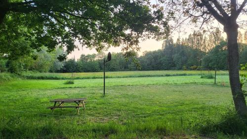 a picnic table in a field next to a tree at L'échappée Verte in Chambellay