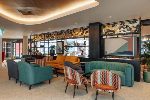 a lobby with couches and chairs and a television at Hotel Indigo London Clerkenwell by IHG in London