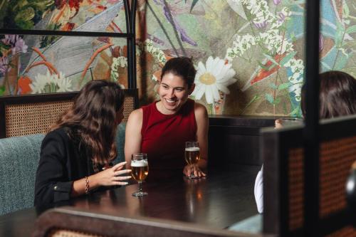 two women sitting at a table with glasses of wine at Hotel Indigo London Clerkenwell by IHG in London