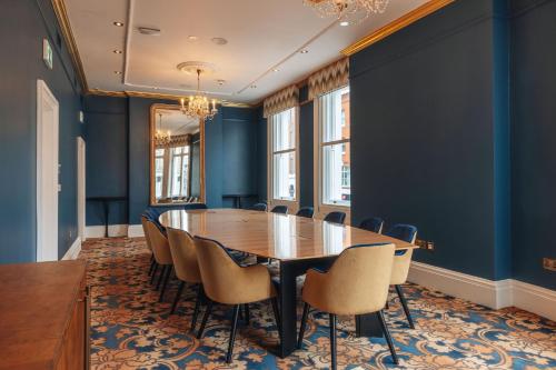 a conference room with a wooden table and chairs at Hotel Indigo London Clerkenwell by IHG in London