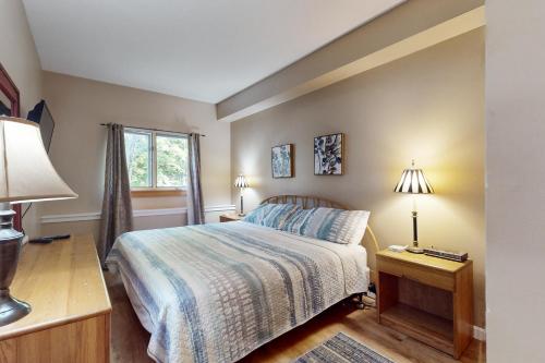 un dormitorio con una cama y una ventana en The Woods - Village 4, en Killington