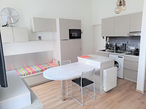 une petite cuisine avec une table et une table et des chaises dans l'établissement Lumineux studio meublé au centre-ville, à Aix-les-Bains