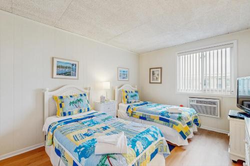 een slaapkamer met twee bedden en een raam bij Colonial Unit #502 in Ocean City