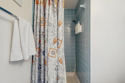 een douchegordijn in een badkamer met blauwe tegels bij Colonial Unit #502 in Ocean City