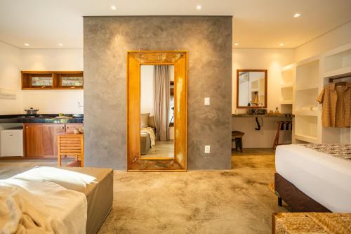 a bedroom with a mirror and a kitchen at Nordisch- Chalés in Prea