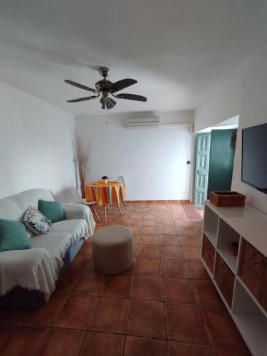 a living room with a couch and a ceiling fan at El rinconcito in Algodonales