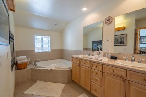 Un baño con dos lavabos, una bañera y un espejo. en RR-Hideaway_Down_Cyn 104, en June Lake