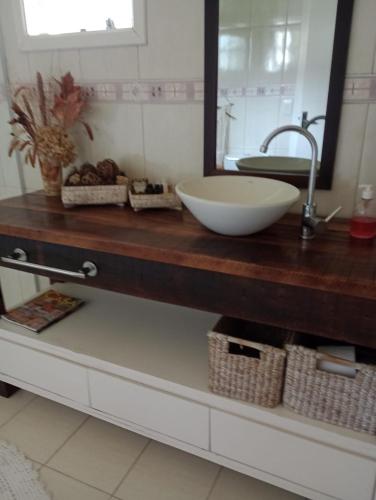 a bathroom counter with a sink and a mirror at Casa Verde do Lago in São Francisco de Paula