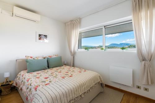 une chambre avec un lit et une grande fenêtre dans l'établissement Charmant 2 pièces - Vue Mer - Marina Baie des Anges, à Villeneuve-Loubet