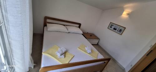 a bedroom with a bed with two towels on it at Apartmani Brnada in Trogir