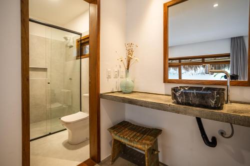 a bathroom with a sink and a mirror and a toilet at Nordisch- Chalés in Prea